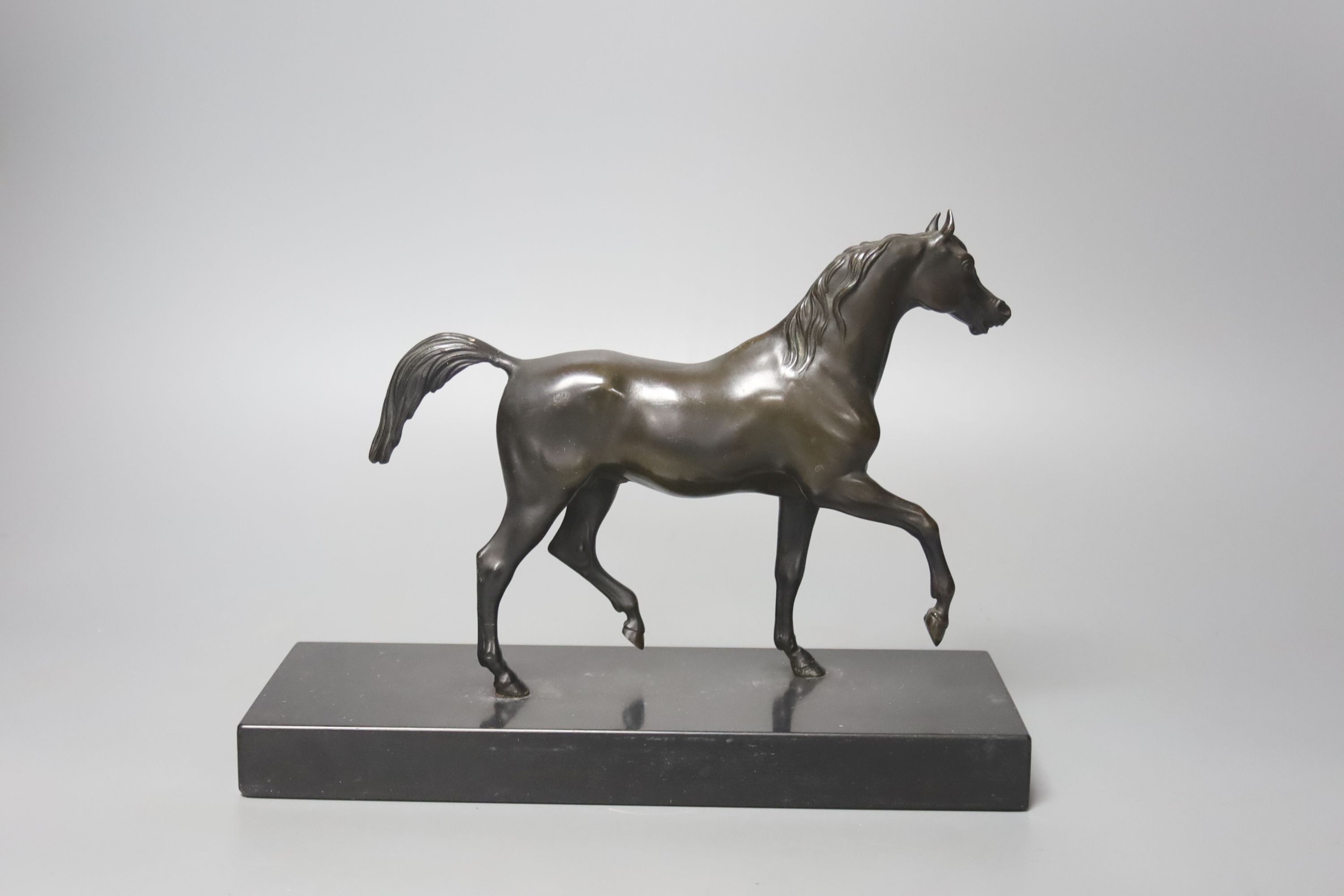 A bronze figure of a prancing horse, on a black marble plinth, 26cm